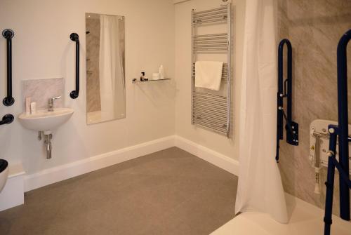 a white bathroom with a sink and a shower at Ballyronan Marina On-Water Glamping Pods in Ballyronan