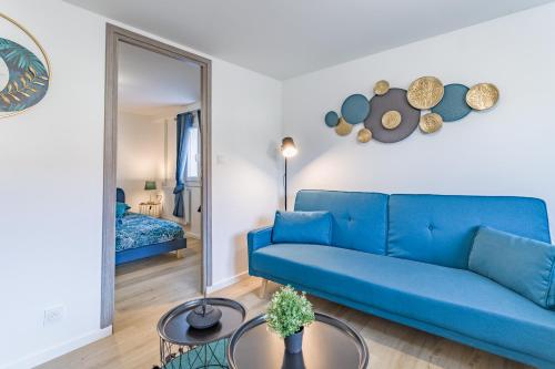 un canapé bleu dans un salon avec un miroir dans l'établissement Le Cosy - Providence - Parking - Terrasse, à Troyes