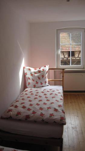 a bed in a room with a pillow and a window at Winzeranwesen - Weingut Christian Eberley - Haupthaus I MINDESTAUFENTHALT 4 NÄCHTE - MINIMUM STAY 4 NIGHTS in Neustadt an der Weinstraße