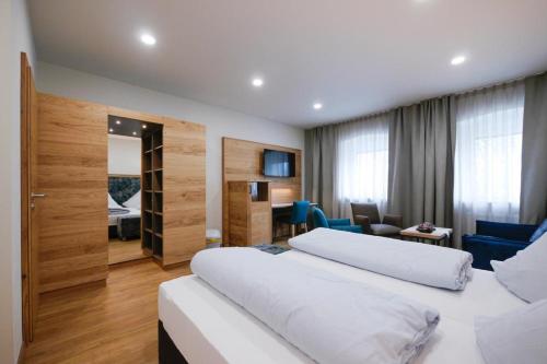 1 dormitorio con 2 camas y sala de estar en Landhotel Zum Jägerstöckl en Grafenau