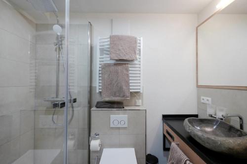 a bathroom with a sink and a glass shower at Landhotel Zum Jägerstöckl in Grafenau