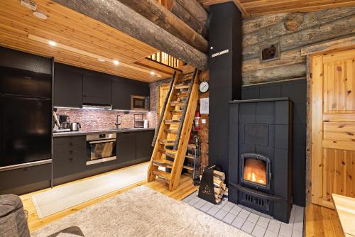 a kitchen with a woodburning stove and a staircase at UnelmaPirkelo in Ruka