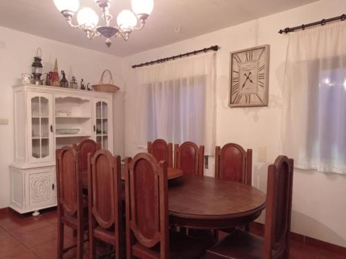 jadalnia ze stołem, krzesłami i zegarem w obiekcie Gerês e Cabreira - Casa Alexandrina Vilar w mieście Frades