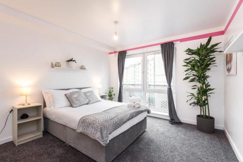 1 dormitorio con cama y ventana grande en Modern Spacious 3 Bedroom City Centre Apartment - Free Parking - Private Balcony en Edimburgo