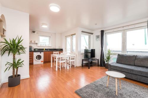 een woonkamer met een bank en een tafel bij Modern Spacious 3 Bedroom City Centre Apartment - Free Parking - Private Balcony in Edinburgh