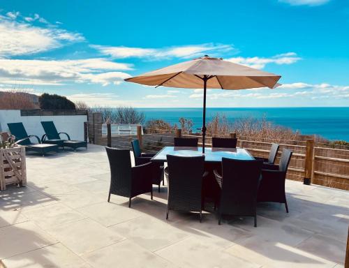 a patio with an umbrella and a table and chairs at Chesil View in Castletown