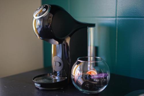 a coffee maker sitting on a counter next to a glass at Apartment Secret in Jonava