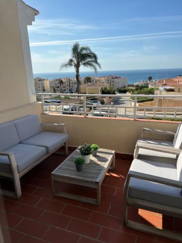 a living room with a couch and a table on a balcony at OCEAN VIEW VILLA BELAMAR in Luz
