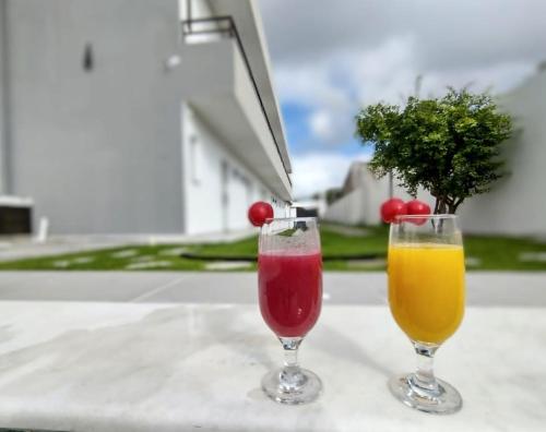 マレシャウ・デオドーロにあるPousada dos Sonhos Francêsのテーブルに座ったグラスドリンク2杯