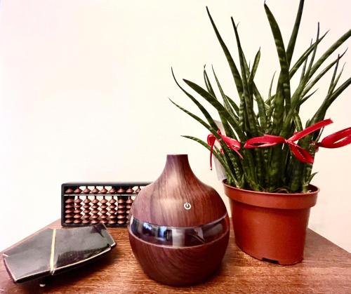 a wooden table with a vase and a potted plant at Mey’s Condo in Pasig - 1BR with Balcony in Manila