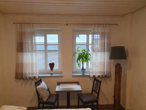 a room with two windows and a table and chairs at Bleibe in der Brandgasse in Alken