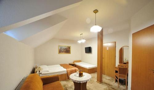 1 dormitorio con cama, sofá y mesa en Na Kamieniu Hotel & Spa en Olesno