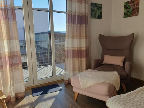a living room with a chair and a balcony at Bleibe in der Brandgasse in Alken