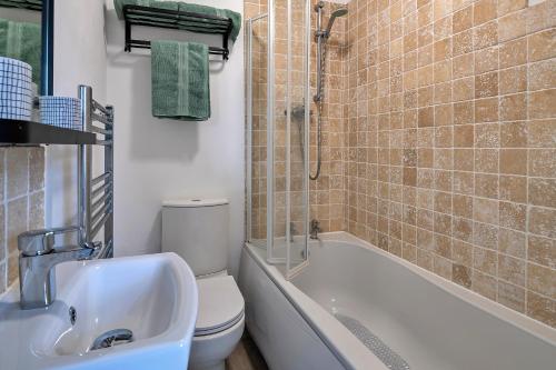 La salle de bains est pourvue d'un lavabo, de toilettes et d'une douche. dans l'établissement Finest Retreats - Smithfields, à Llanrwst