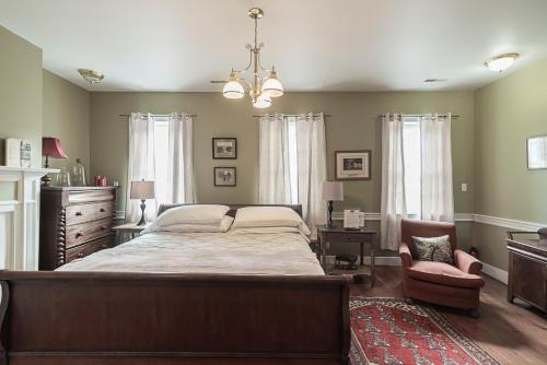 a bedroom with a large bed and a chair at Light Horse Inn in Harpers Ferry