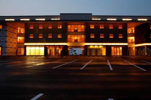 an empty parking lot in front of a building at Bayside Square Kaike Hotel in Yonago