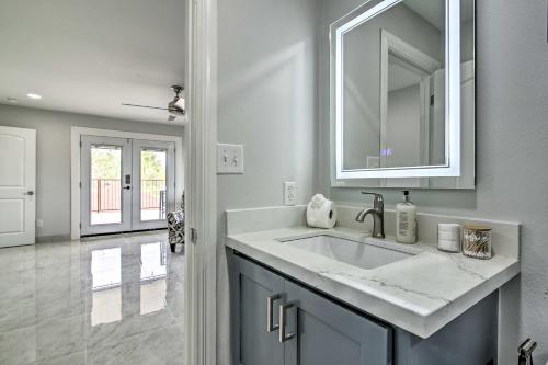 a white bathroom with a sink and a mirror at Cozy Texas Gulf Coast Vacation Rental with Patio! in Brownsville
