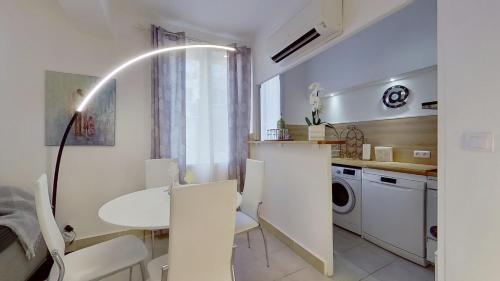 a kitchen with a table and a white table and chairs at Le Pytheas Vieux Port Marseille in Marseille