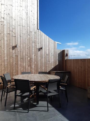 a wooden table and chairs on a roof at Het Helmgras in Middelkerke