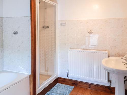 ein Bad mit einer Dusche und einem Waschbecken in der Unterkunft Greenrigg Cottage in Caldbeck