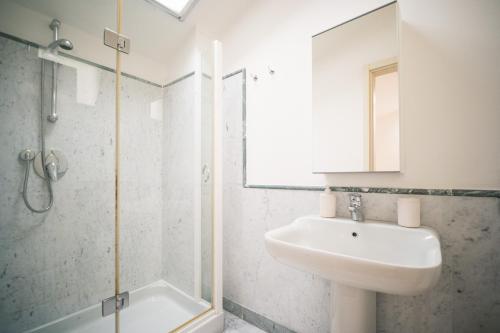 a bathroom with a sink and a shower and a mirror at Corte Lotti Charming Loft in Pietrasanta