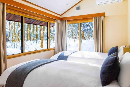 a bedroom with two beds and a window at Sakura 88 - Luxury Villa - 280sqm 4 bedrooms in Hakuba