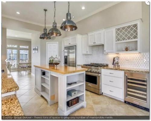 a large kitchen with white cabinets and a counter top at SEAFOAM - Beautiful Luxury Beachside Village Home - Breathtaking Ocean Views- Full Reno in Galveston