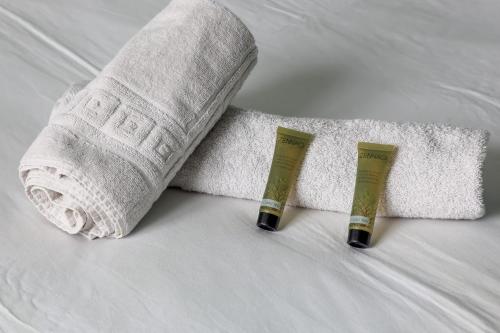 - une serviette roulée et une chaussette sur un lit dans l'établissement Appartement Tandou - Welkeys, à Paris