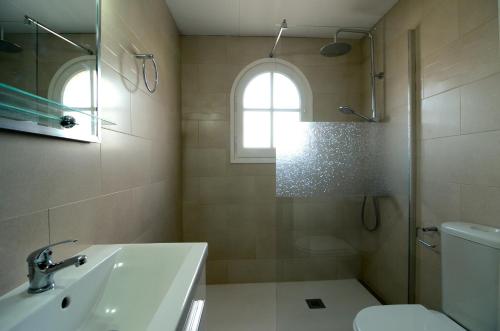 baño con lavabo y aseo y ventana en Jardins del mar 83-D, en L'Estartit