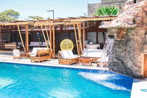 una piscina con sillas y una casa en Hotel Pousada Mahon Mar, en Praia do Frances
