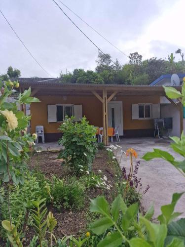 une maison avec une terrasse couverte et un patio dans l'établissement Pomme de Pin, à Cilaos