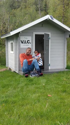 a man and a child sitting in front of a shed at Évika boutique hotel in Eskilsby