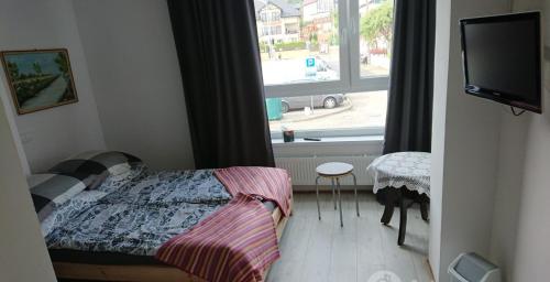 a small bedroom with a bed and a window at Sercówka Międzyzdroje in Międzyzdroje
