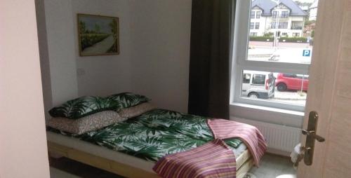 a small bed in a room with a window at Sercówka Międzyzdroje in Międzyzdroje