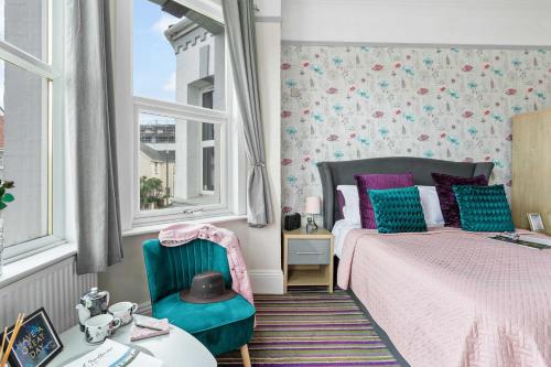 a bedroom with a bed and a table and windows at Cherwood Guest House in Paignton