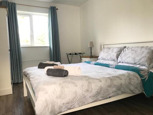 a bedroom with a bed with two towels on it at Cree River Cottage in Creegh