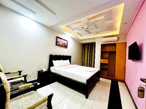 1 dormitorio con 1 cama en una habitación con paredes rosas en AAKAS HOTEL & RESTAURANT en Muzaffarabad