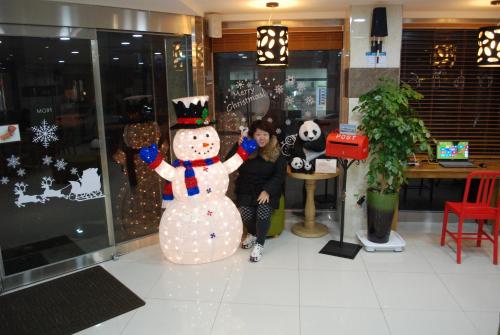 a woman standing next to a snowman in a store at Jeju R Hotel & Guesthouse in Jeju