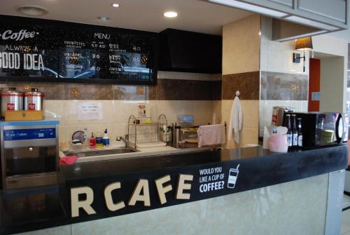 a kitchen with a counter with a cafe sign on it at Jeju R Hotel & Guesthouse in Jeju