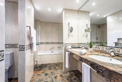 ein Badezimmer mit einem Waschbecken und einer Badewanne in der Unterkunft Estival Park Silmar in La Pineda