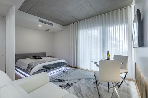 a white bedroom with a bed and a table at Apartamento Vista Mar in Canidelo