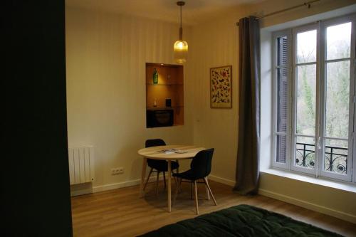 einen Tisch und Stühle in einem Zimmer mit Fenster in der Unterkunft Le soleil du Revard in Aix-les-Bains