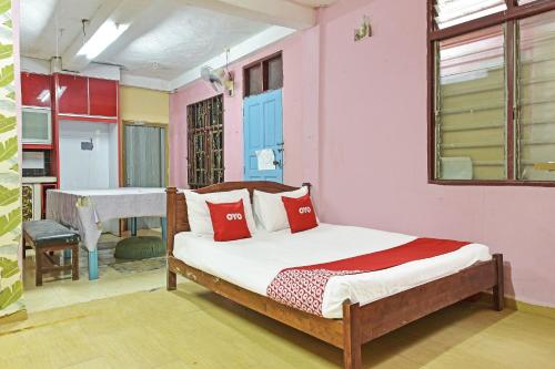 a bedroom with a bed with red pillows on it at OYO 90740 Paddington Lodge in Kota Bharu