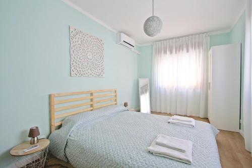 a bedroom with a bed with two towels on it at Apartamento SofiSara in Tavira