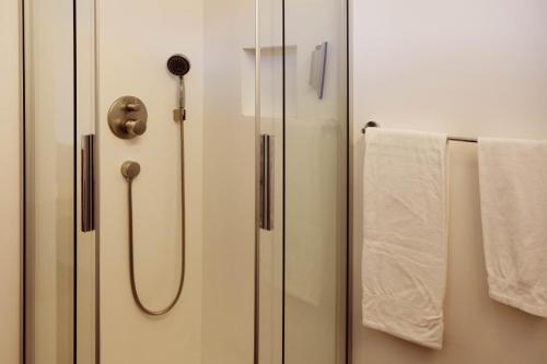a bathroom with a glass shower door with towels at Buchtoase in Spiez