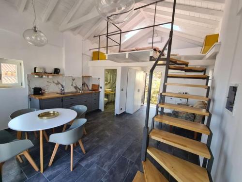 a room with a spiral staircase and a table and chairs at Gythio townhouse in Gythio