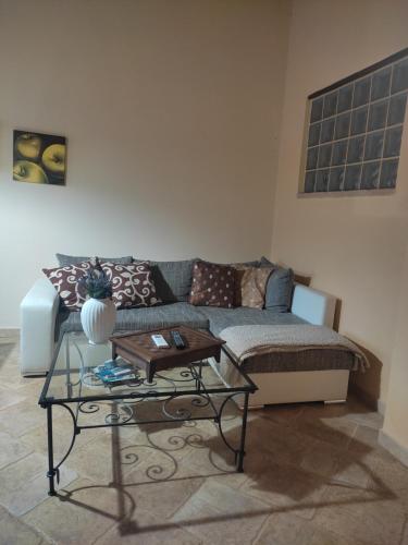 uma sala de estar com um sofá e uma mesa em Alex's Apartment em Iglesias