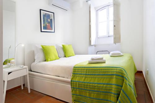 タヴィラにあるYellow Stripeの白いベッドルーム(緑の枕が付くベッド付)