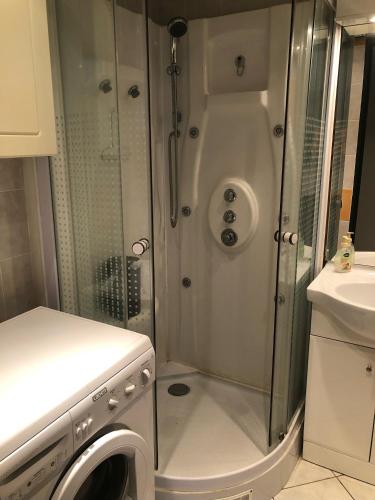 une salle de bain avec douche et machine à laver dans l'établissement Location Vacances entre mer et montagnes, à Argelès-sur-Mer
