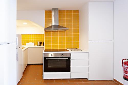 タヴィラにあるYellow Stripeの黄色のタイル張りのキッチン(コンロ付)